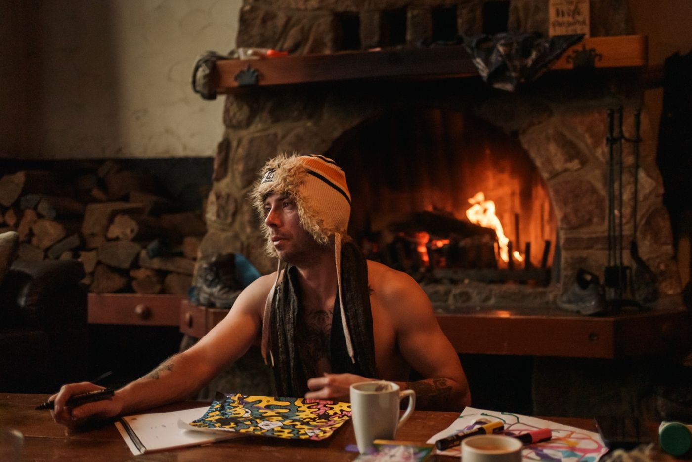 A man drawing by a stone fireplace