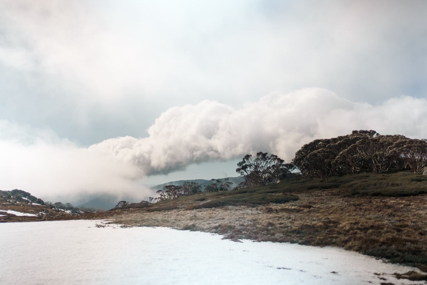 Cloud rolling over a snowy ridge